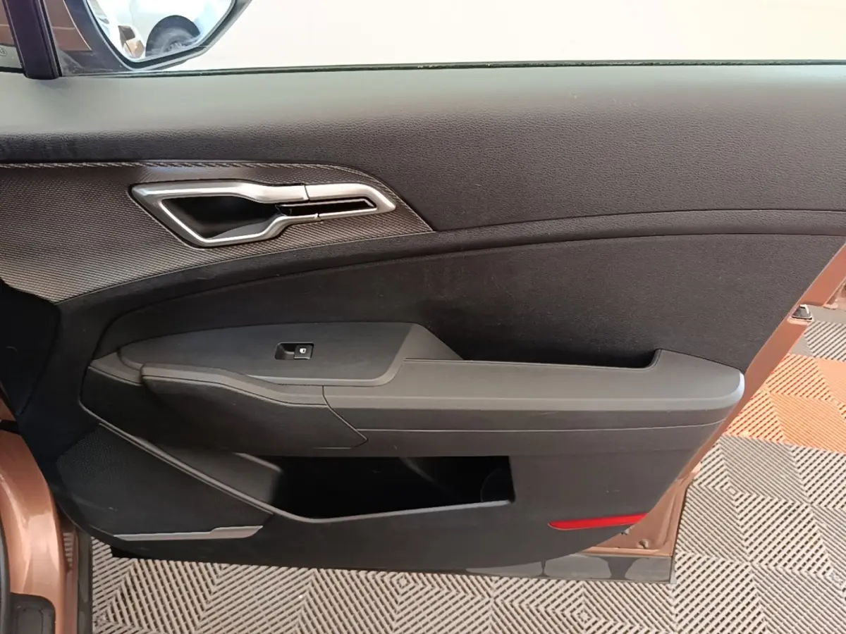 Vue intérieure de la porte avant gauche beige du KIA SPORTAGE 2022 avec poignée argentée et commande de vitre.