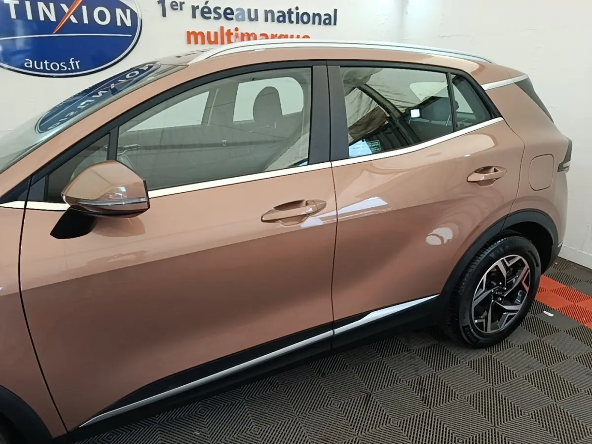 Vue latérale droite du KIA SPORTAGE beige 2022, mettant en valeur les jantes alliage et les rétroviseurs électriques.