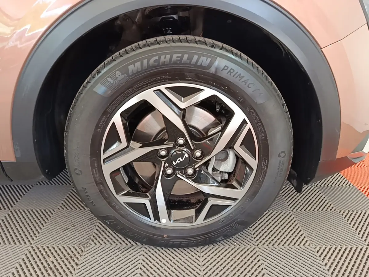 Gros plan sur la roue arrière droite du KIA Sportage beige 2022 avec jante alliage et pneu Michelin visible.