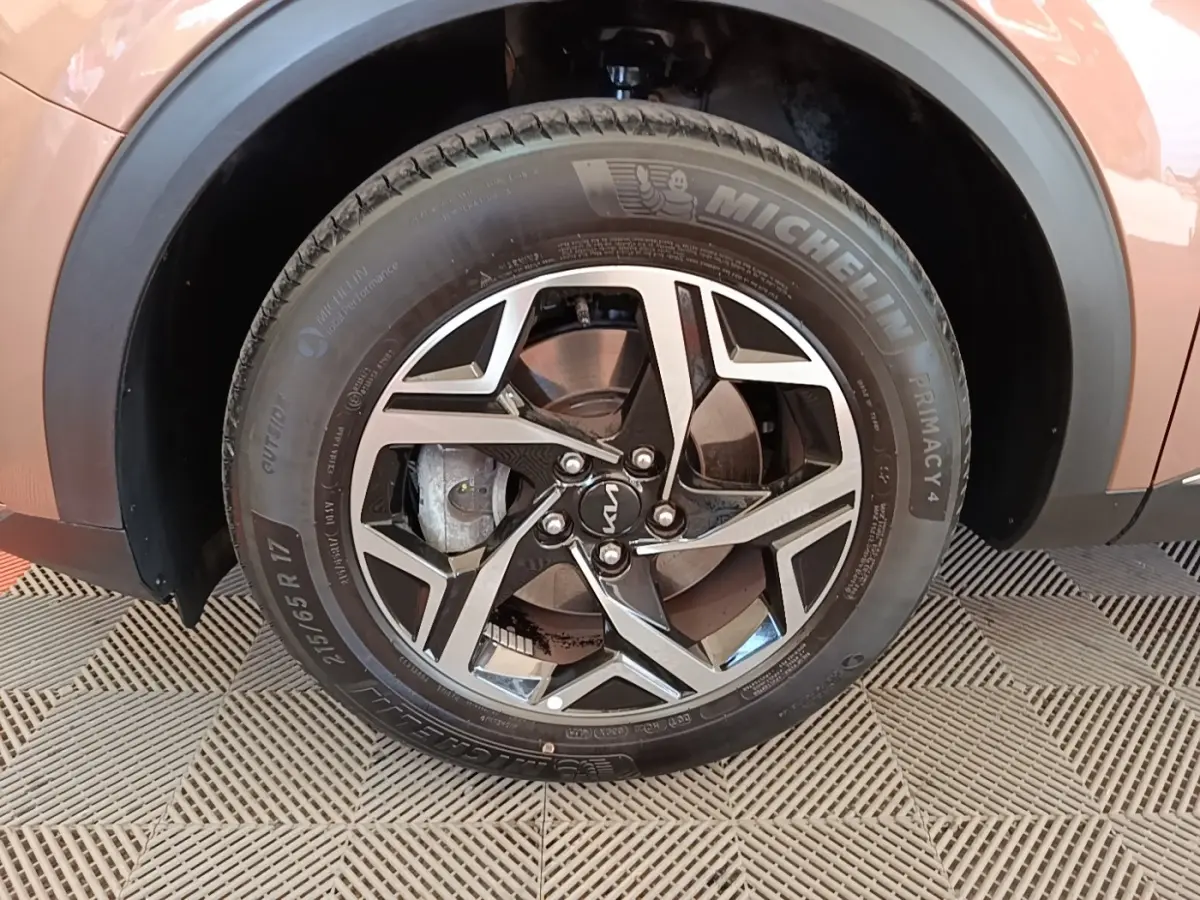 Gros plan sur la roue avant droite beige d’un KIA SPORTAGE 2022 avec jante alliage et pneu Michelin.