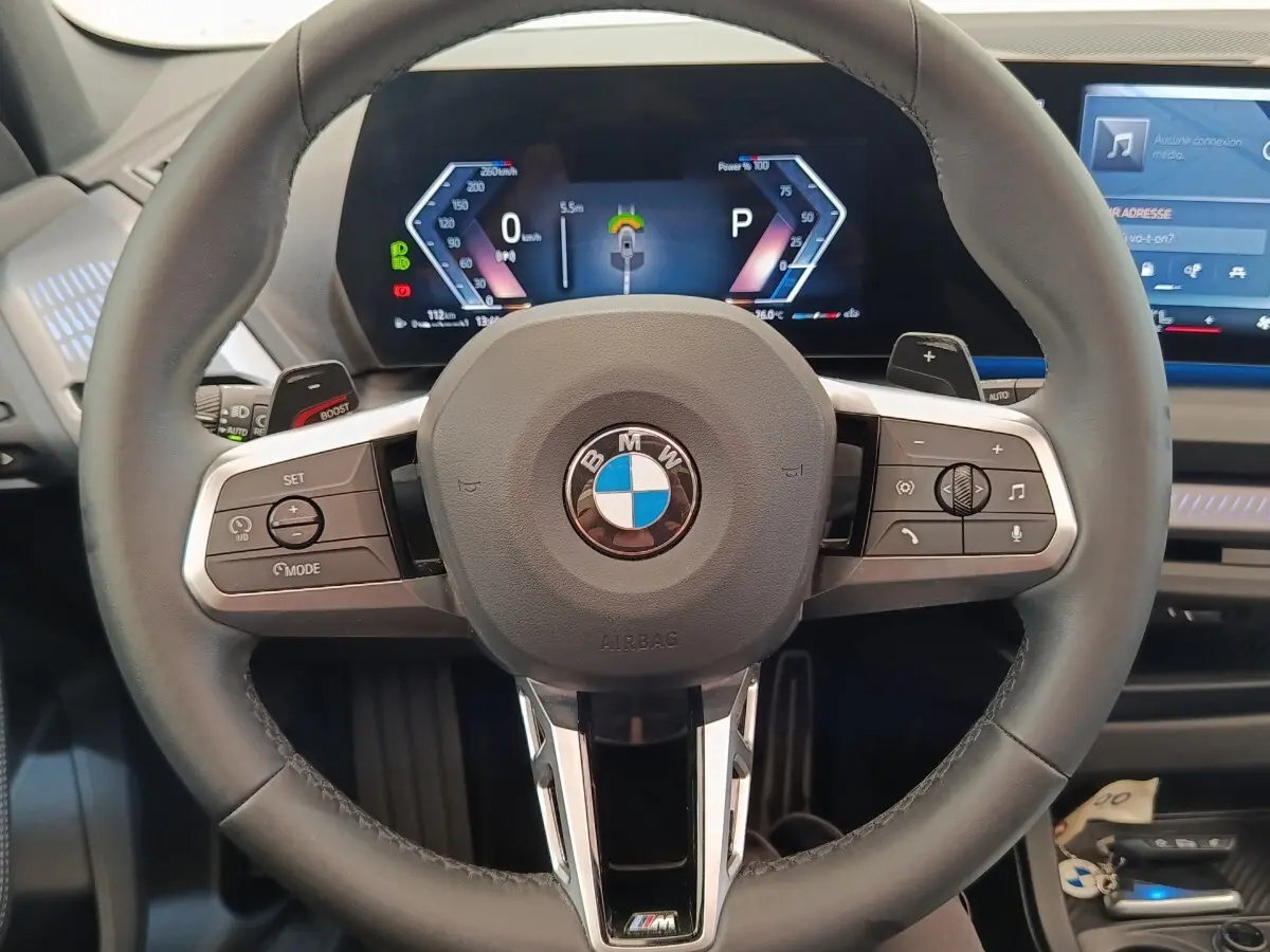 Vue rapprochée du volant cuir M Sport et du combiné numérique de la BMW Série 1 120 DKG7 hybride 2025.