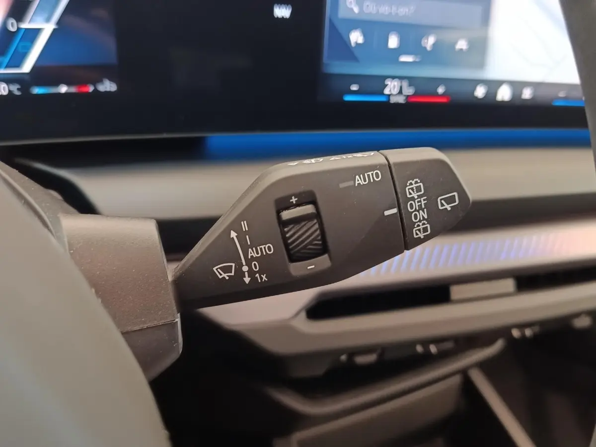 Gros plan sur la commande d’essuie-glace à gauche du volant dans l’habitacle gris clair de la BMW Série 1 120 DKG7 M Sport 2025.