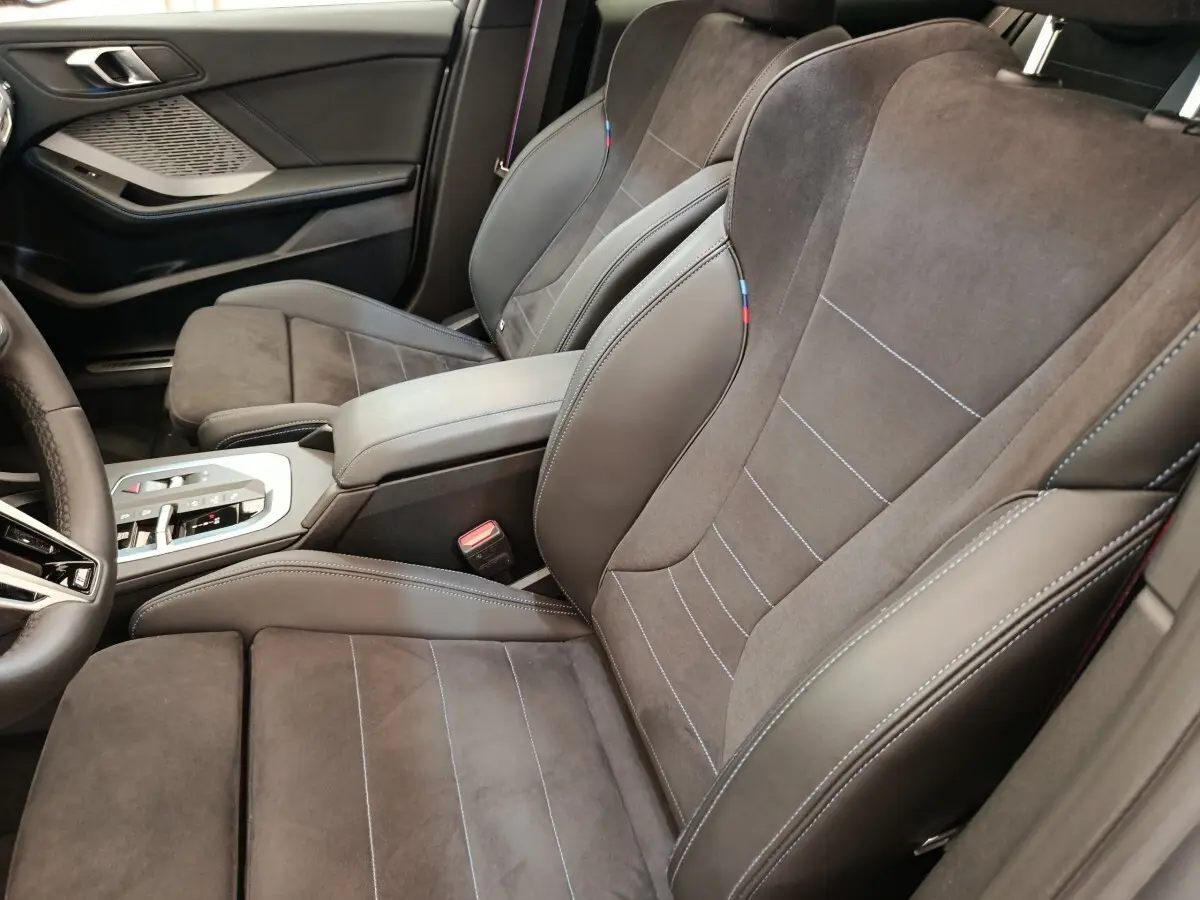 Vue intérieure côté droit des sièges avant en cuir et alcantara gris foncé de la BMW Série 1 120 DKG7 M Sport 2025.