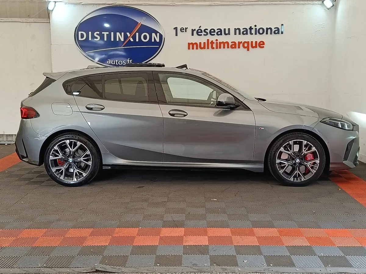 BMW Série 1 120 DKG7 M Sport gris clair vue de profil côté gauche avec jantes alliage et étriers rouges.
