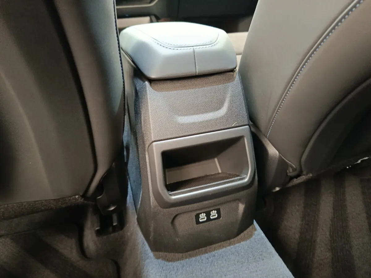 Détail de la console arrière noire avec ports USB dans l’habitacle de la BMW Série 1 120 DKG7 M Sport gris clair.