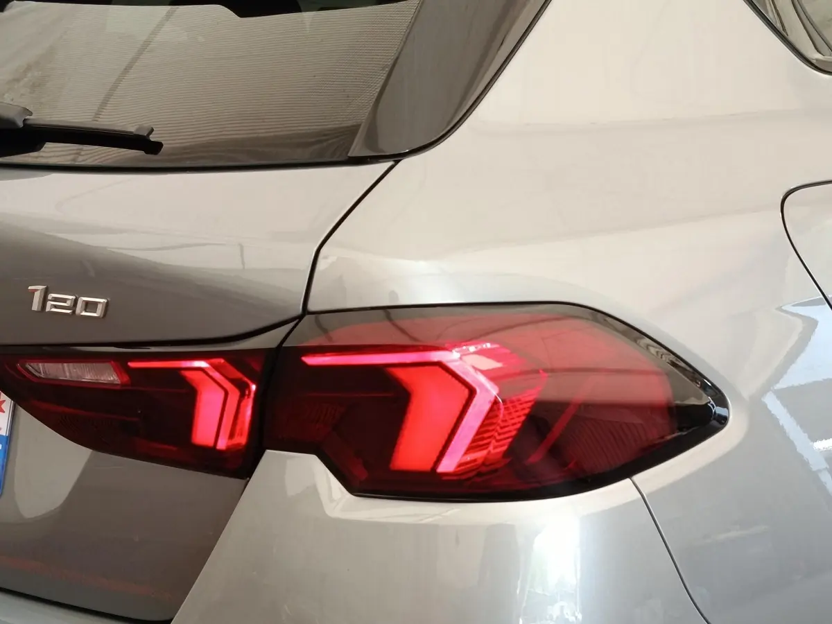 Gros plan sur le feu arrière droit rouge vif d'une BMW Série 1 120 DKG7 M Sport gris clair, année 2025.