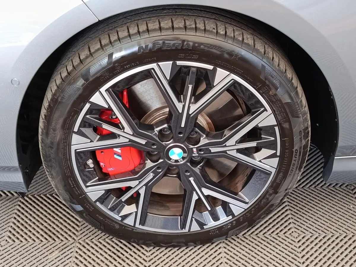 Gros plan sur la roue avant gauche grise d’une BMW Série 1 120 DKG7 M Sport avec étrier de frein rouge distinctif.