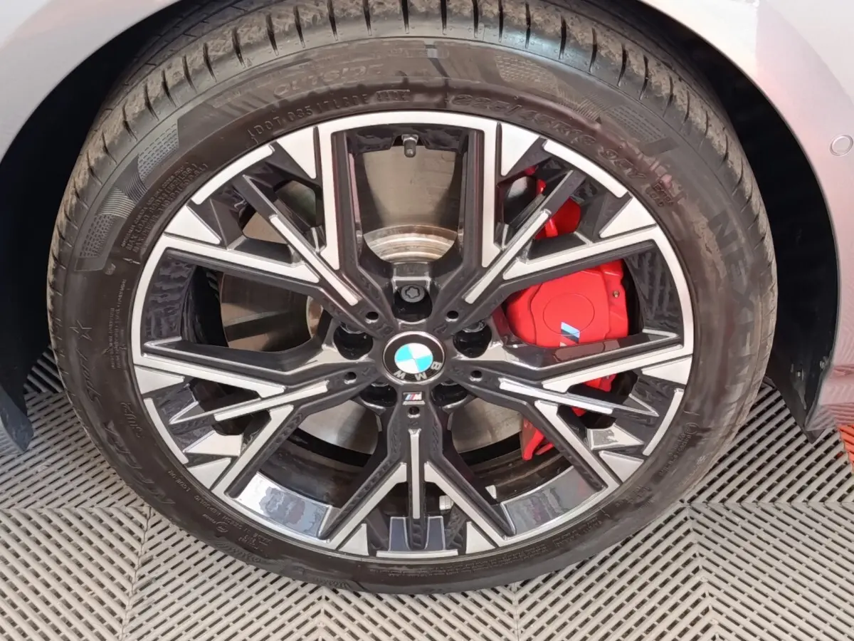 Gros plan sur la roue avant droite de la BMW Série 1 120 DKG7 M Sport gris clair avec étrier de frein rouge M.