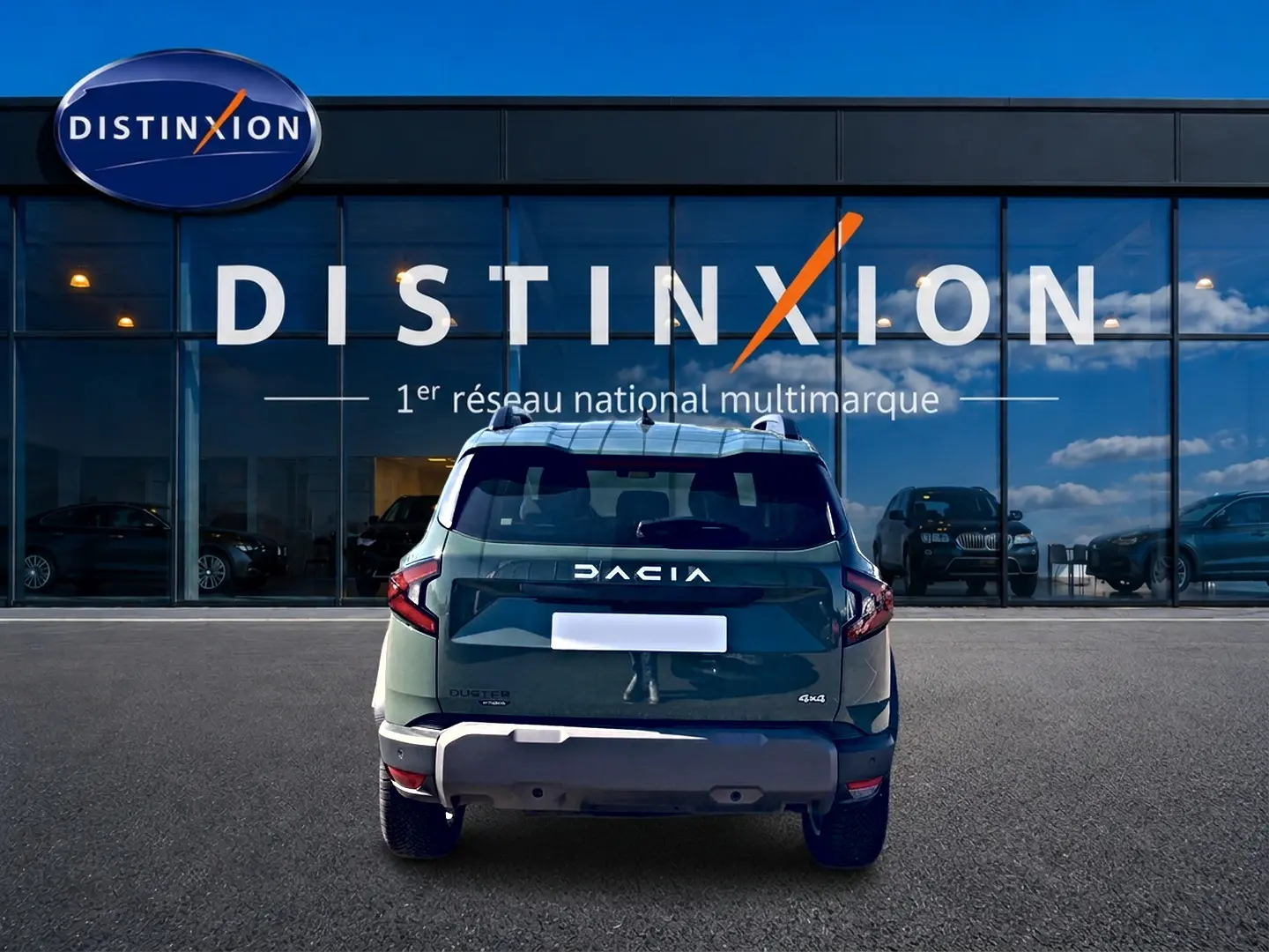 Vue arrière d'un Dacia Duster 1.2 hybrid-g 150 expression 4x4 en kaki lichen, devant une vitrine Distinxion.