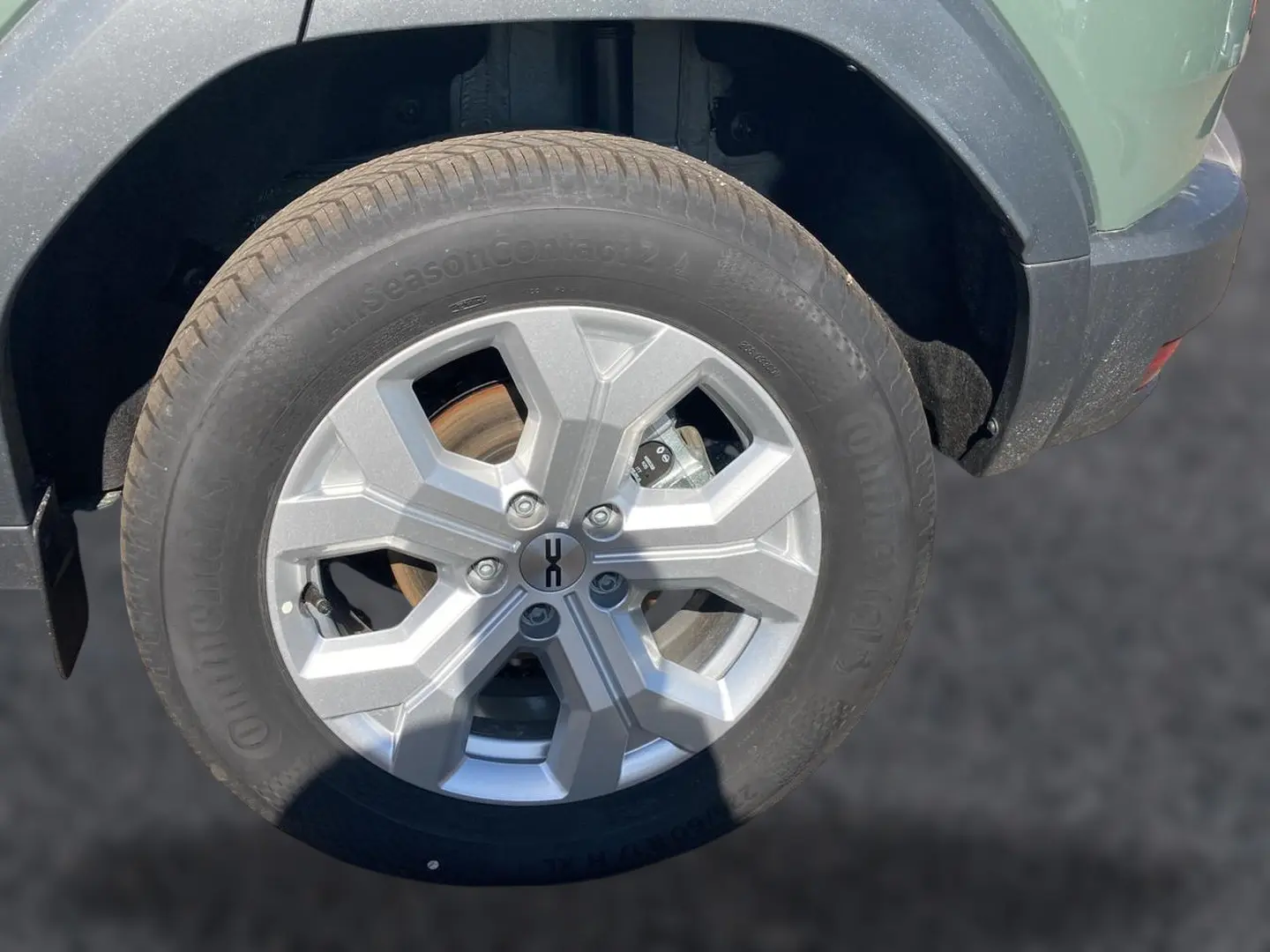 Gros plan sur la roue avant droite du Dacia Duster 2026 kaki lichen, avec jante alu et partie de l'aile visible.