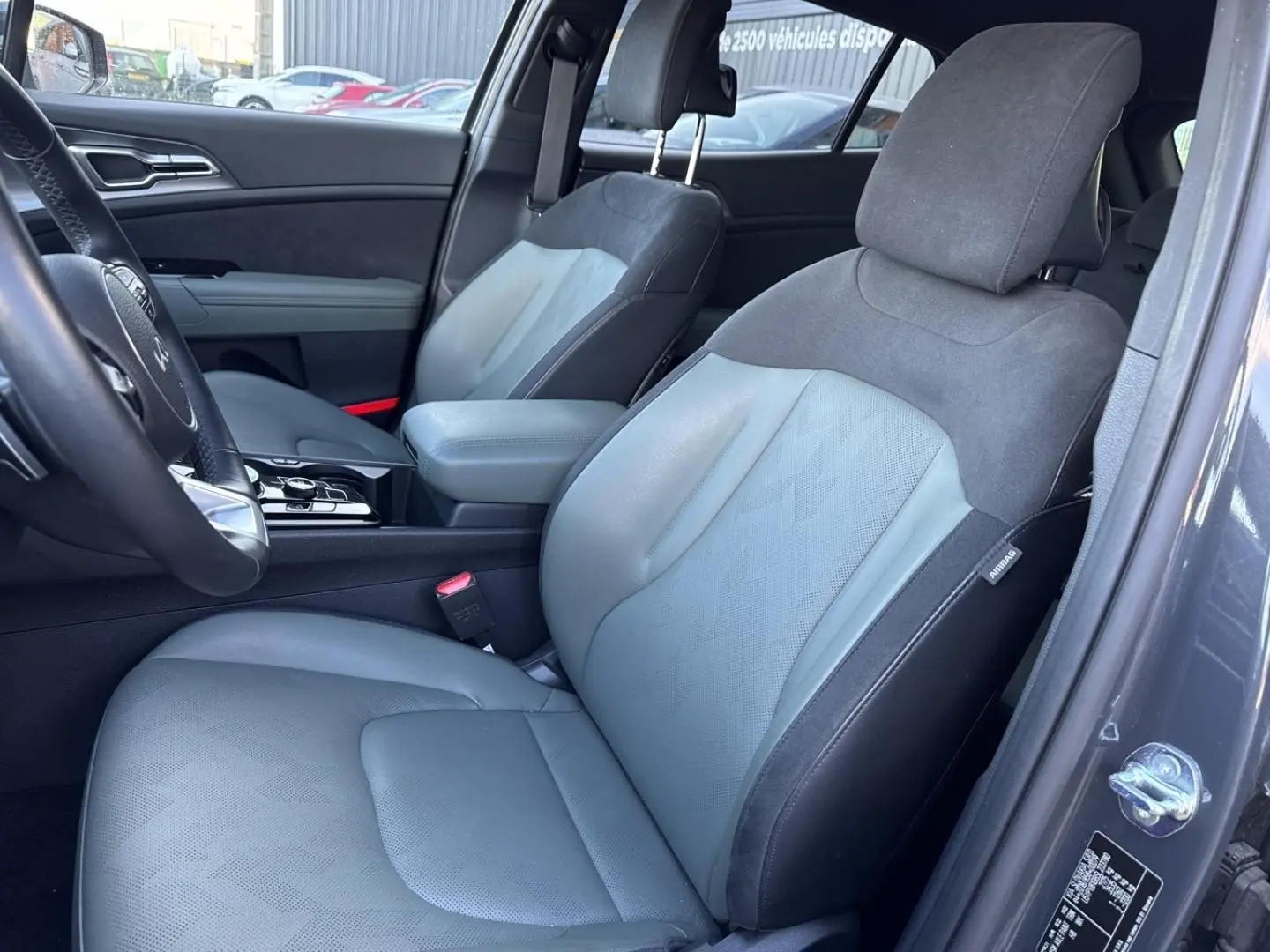 Vue intérieure côté conducteur du Kia Sportage 2025 gris Eclipse, sièges bi-matière synthétique et suédine vert pin.