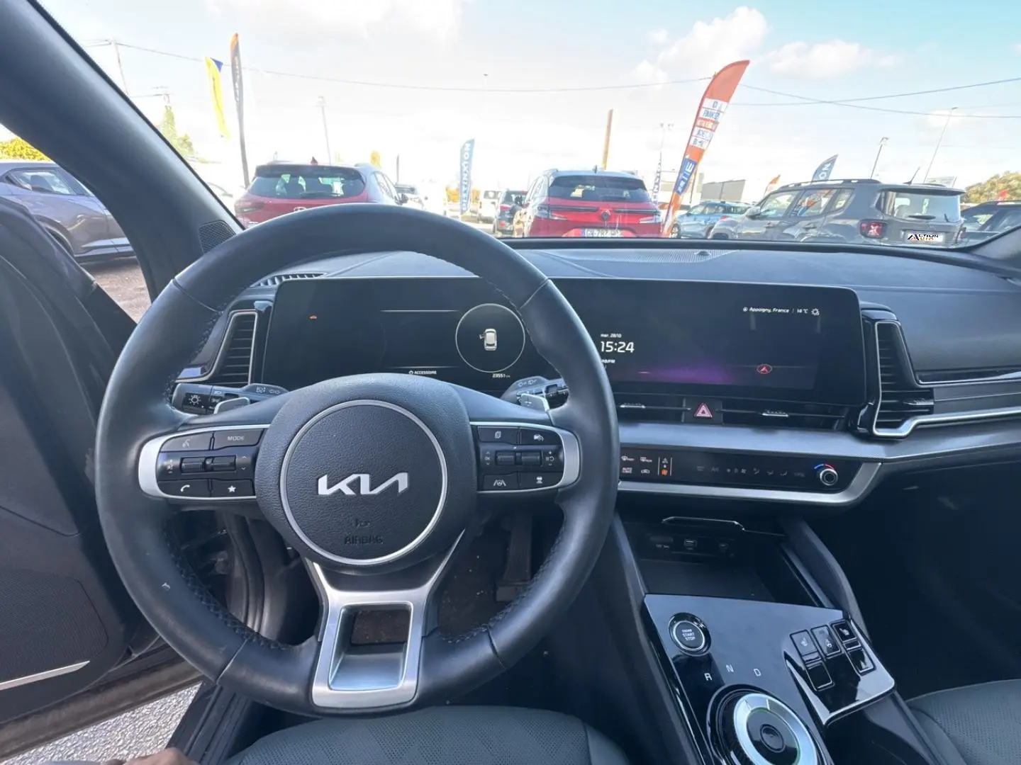 Vue intérieure centrée sur le volant cuir multifonction et l’écran tactile du Kia Sportage gris Eclipse 2025.