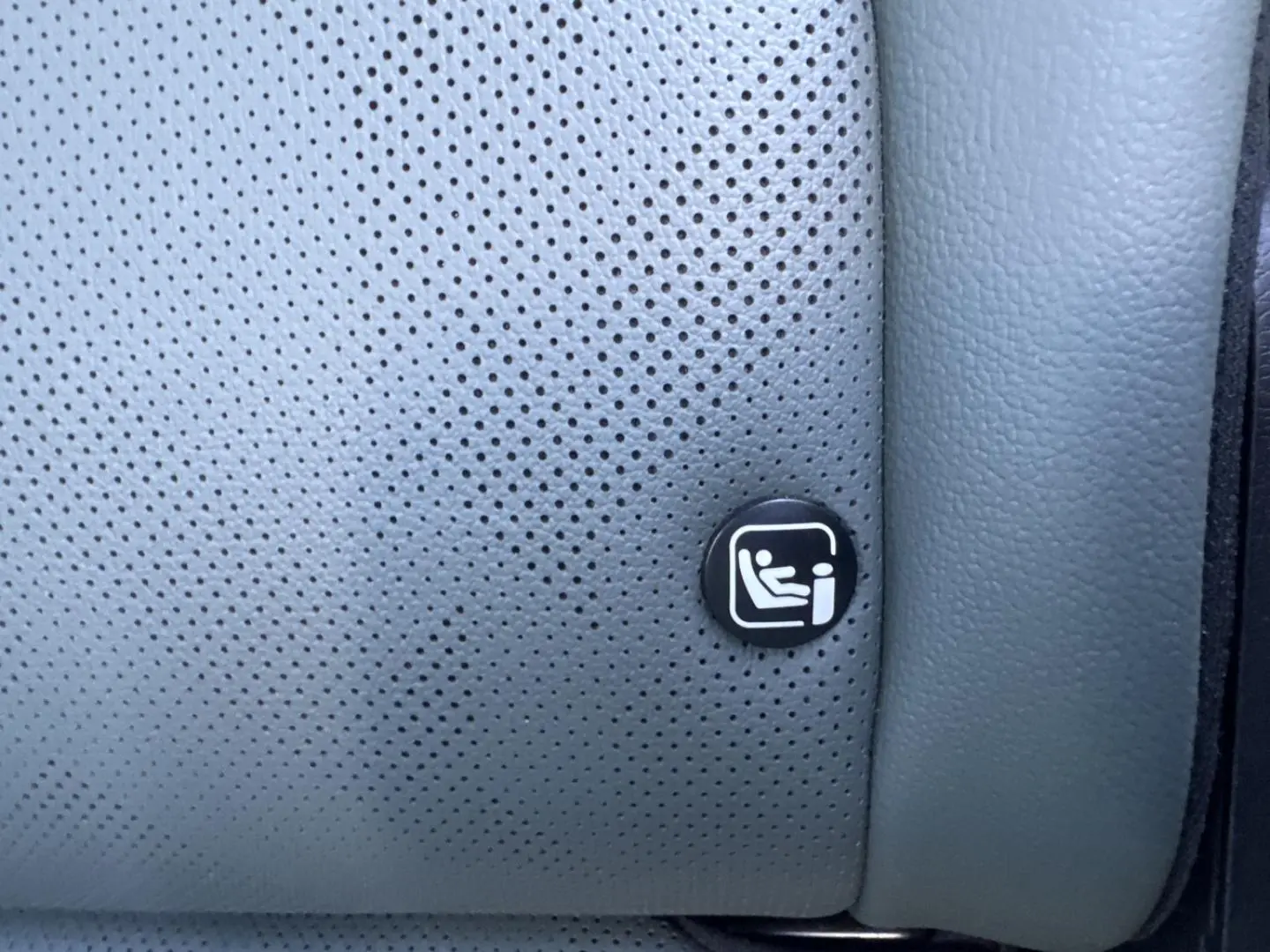 Gros plan sur le logo ISOFIX sur la sellerie grise perforée du siège arrière du KIA SPORTAGE 2025.