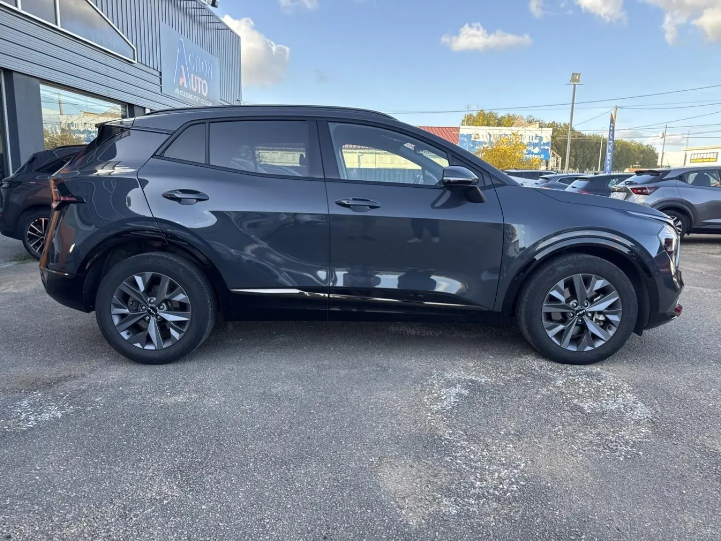 Vue latérale gauche du KIA SPORTAGE 2025 gris Eclipse Métallisée avec jantes alliage et vitres surteintées.