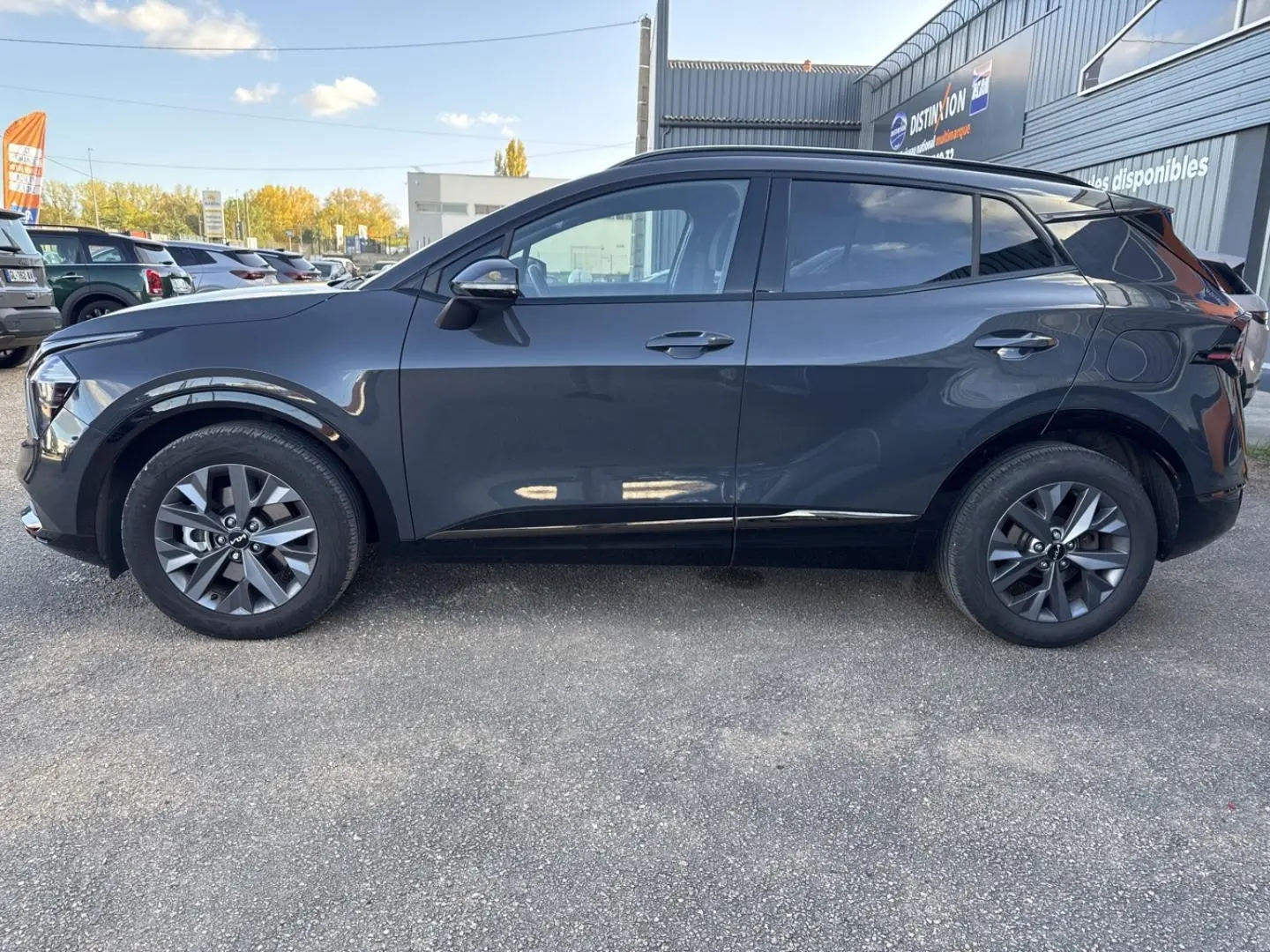 Profil droit d'un KIA SPORTAGE gris Eclipse métallisé 2025, avec jantes alu et vitres surteintées.