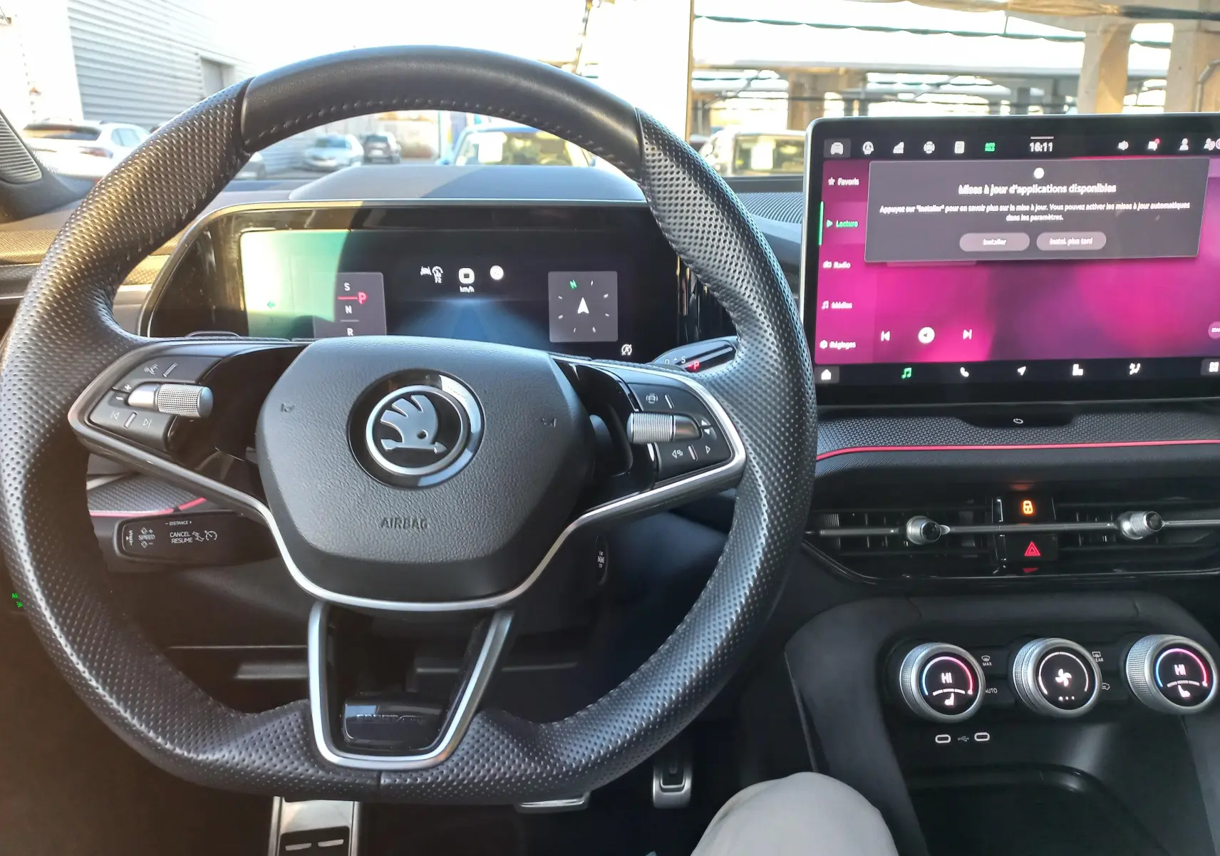 Vue intérieure centrée sur le volant perforé et le grand écran tactile du tableau de bord du Skoda Kodiaq 2024.