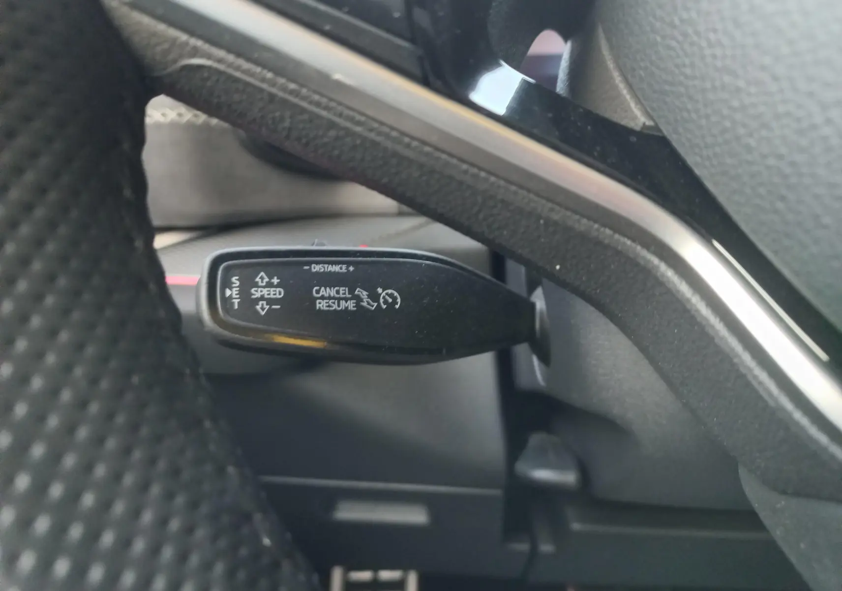 Gros plan sur la commande de régulateur de vitesse du Skoda Kodiaq 2024, intérieur noir avec détails argentés.