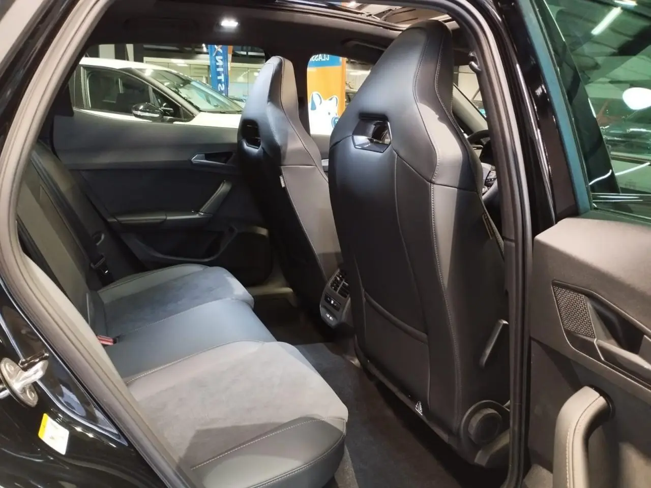 Vue intérieure arrière côté gauche du CUPRA Formentor noir métal, sièges baquets en suédine et cuir noir avec surpiqûres cuivrées.