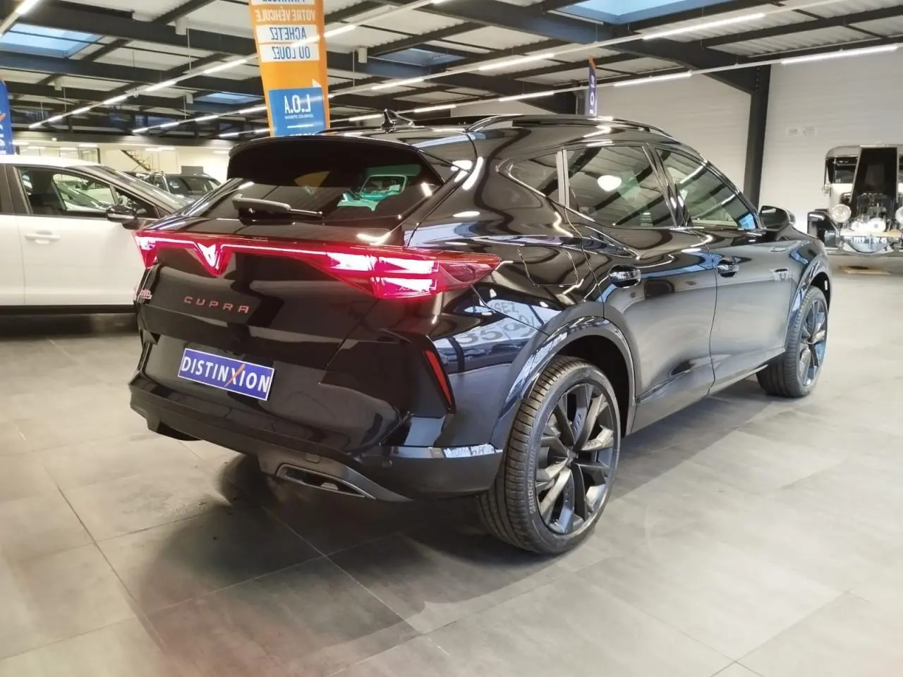 Vue 3/4 arrière droite d'une CUPRA Formentor noire métal avec feux arrière Tri-LED et jantes alliage 19 pouces.