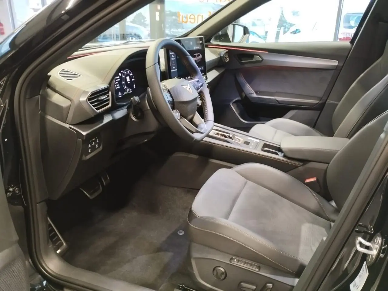 Intérieur avant droit du CUPRA Formentor noir métal, sièges suédine noirs avec surpiqûres cuivrées et tableau de bord digital.