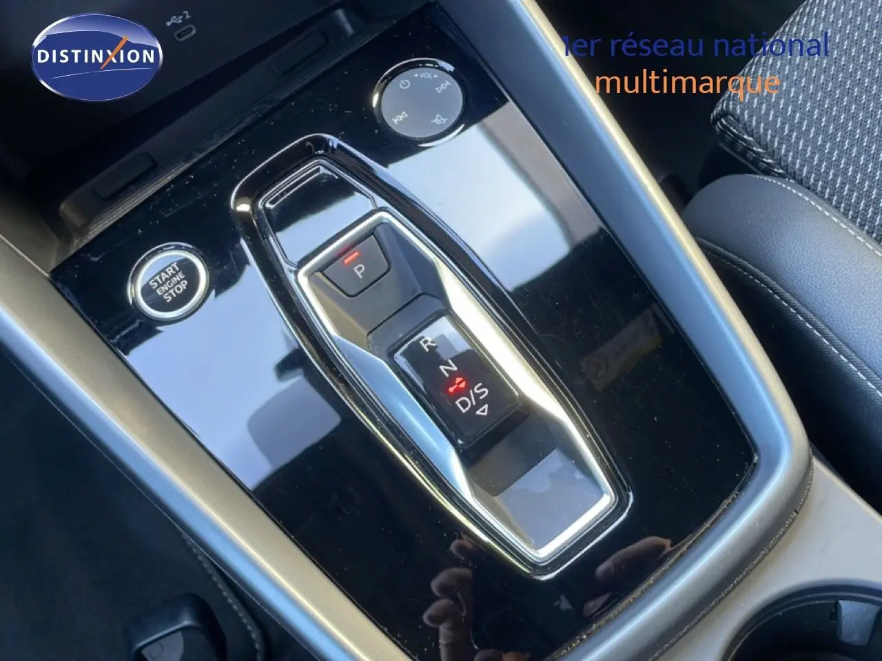 Gros plan sur la console centrale noire brillante de l'Audi A3 Sportback 40 TFSIe avec sélecteur de boîte auto et bouton start/stop.