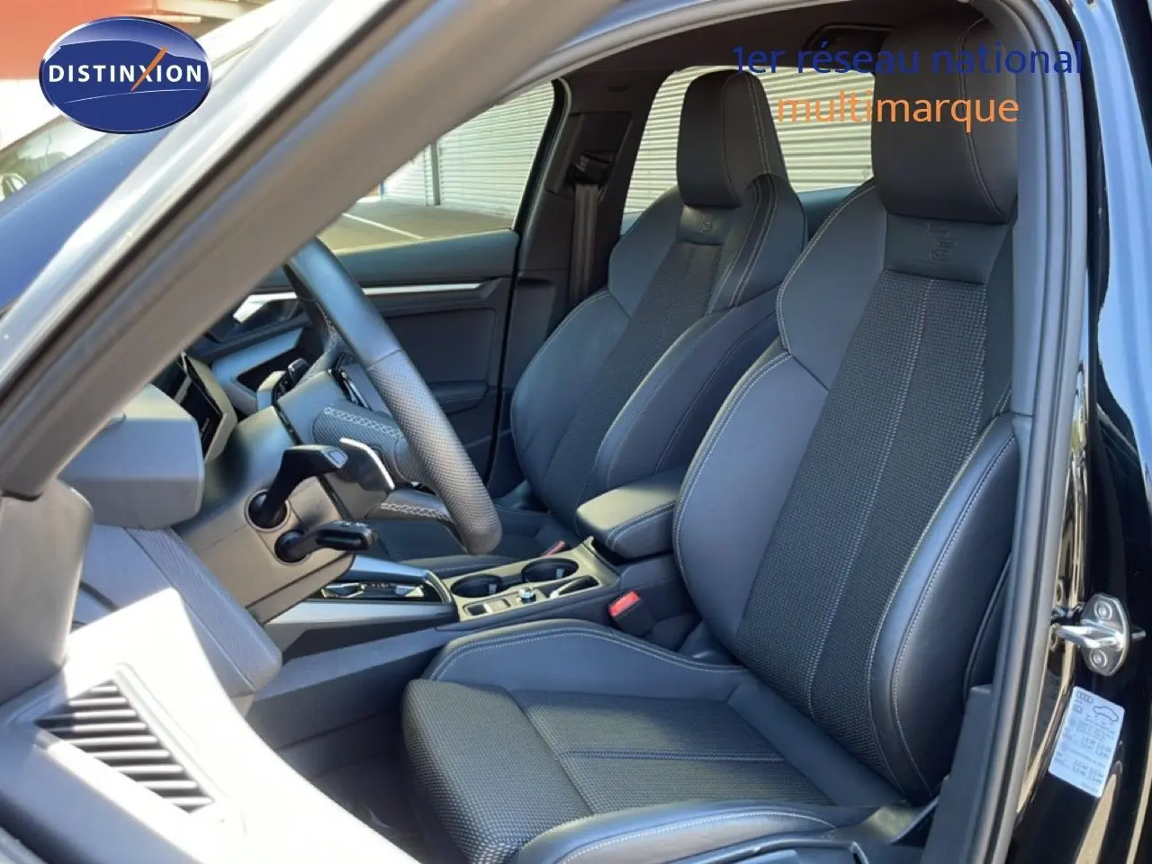 Vue intérieure côté conducteur de l'Audi A3 Sportback 40 TFSIe 2025 avec sièges sport noirs et volant multifonction.
