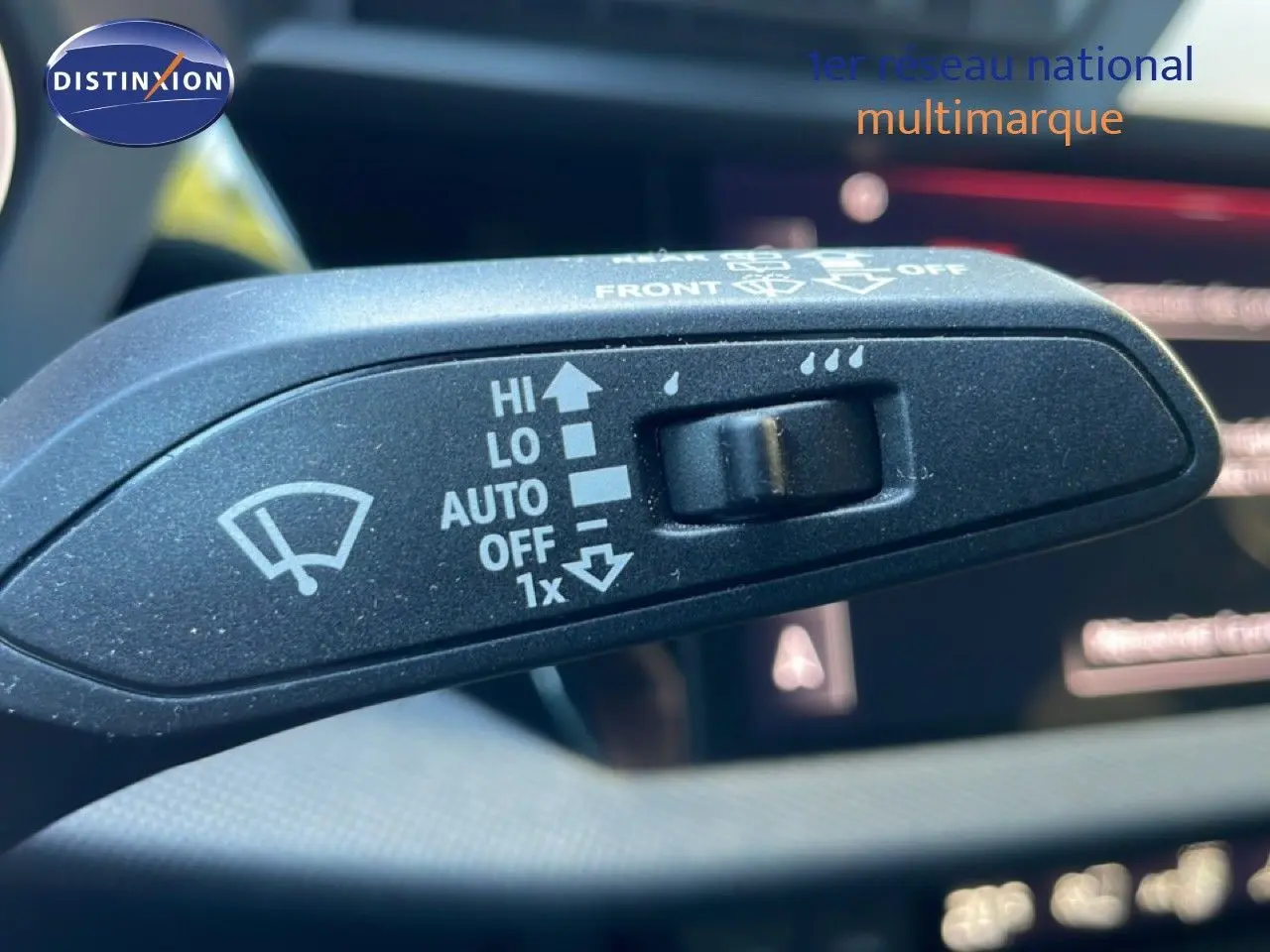 Gros plan sur le commodo d'essuie-glace de l'Audi A3 Sportback 40 TFSIe noir mito metal, avec commandes visibles en intérieur.