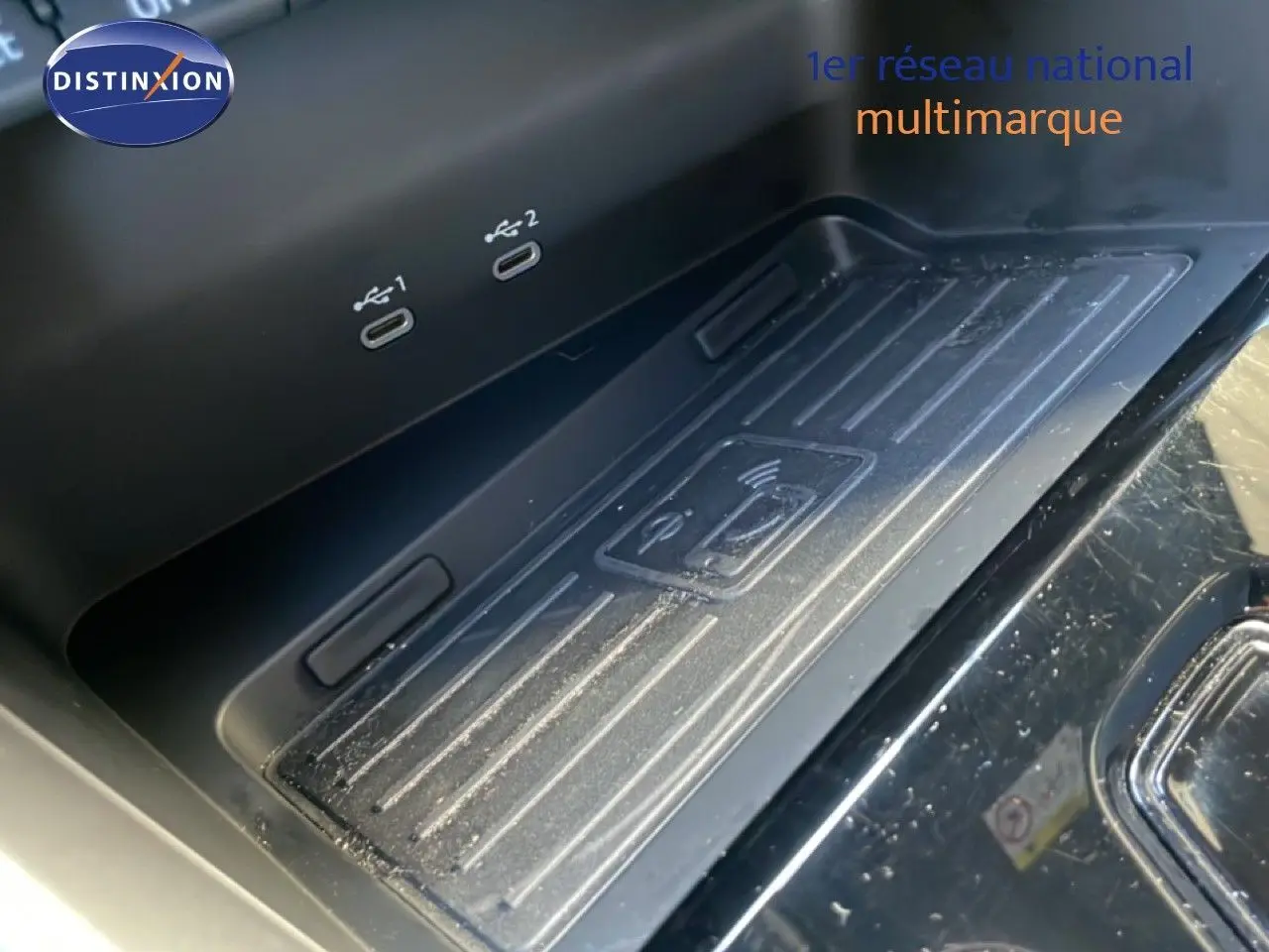 Gros plan sur la console centrale noire avec zone de recharge sans fil et deux ports USB-C dans l'Audi A3 Sportback 2025.