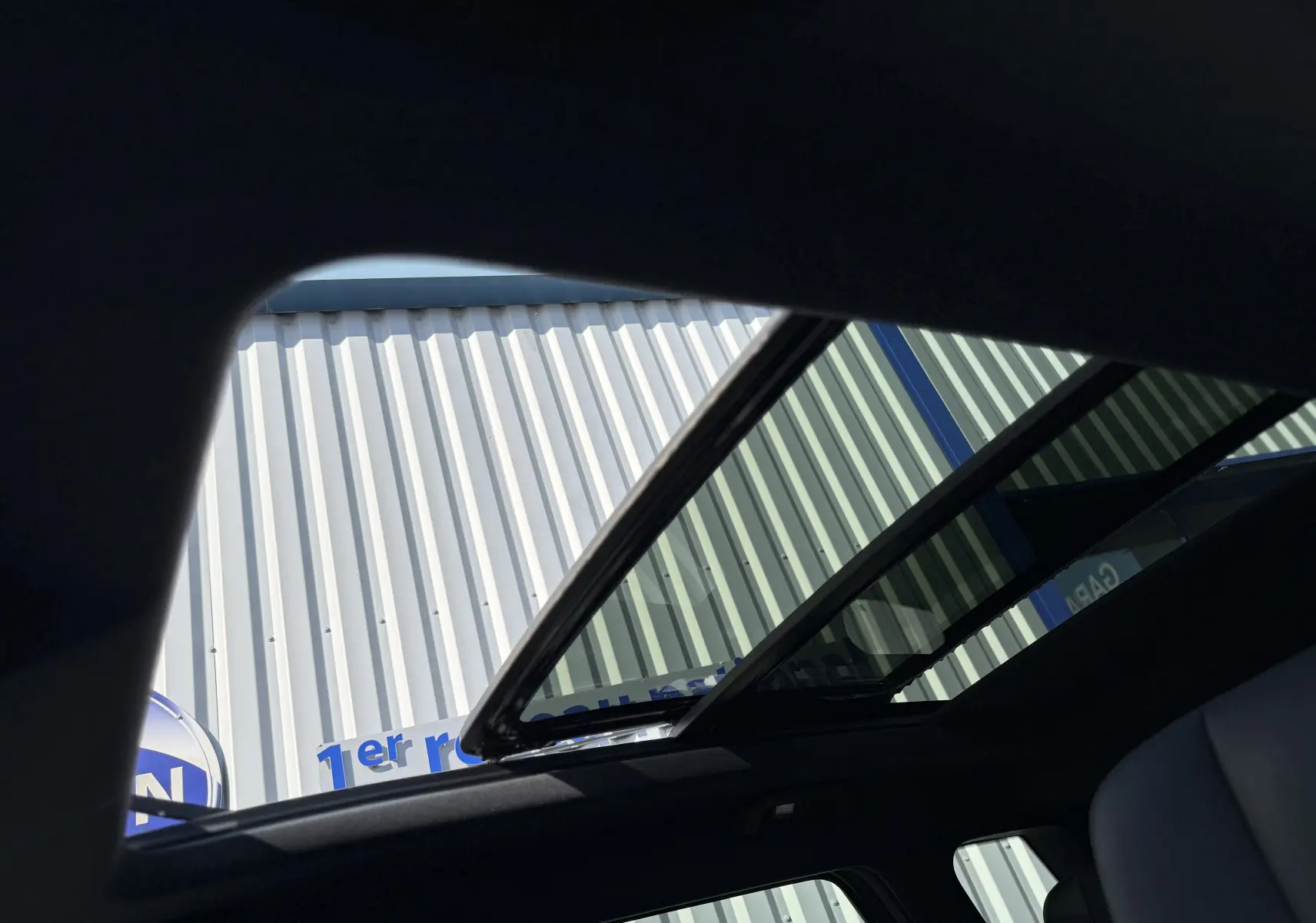 Vue intérieure du toit ouvrant panoramique du JAECOO J7 PHEV blanc khaki, soulignant la luminosité naturelle et l'ouverture.