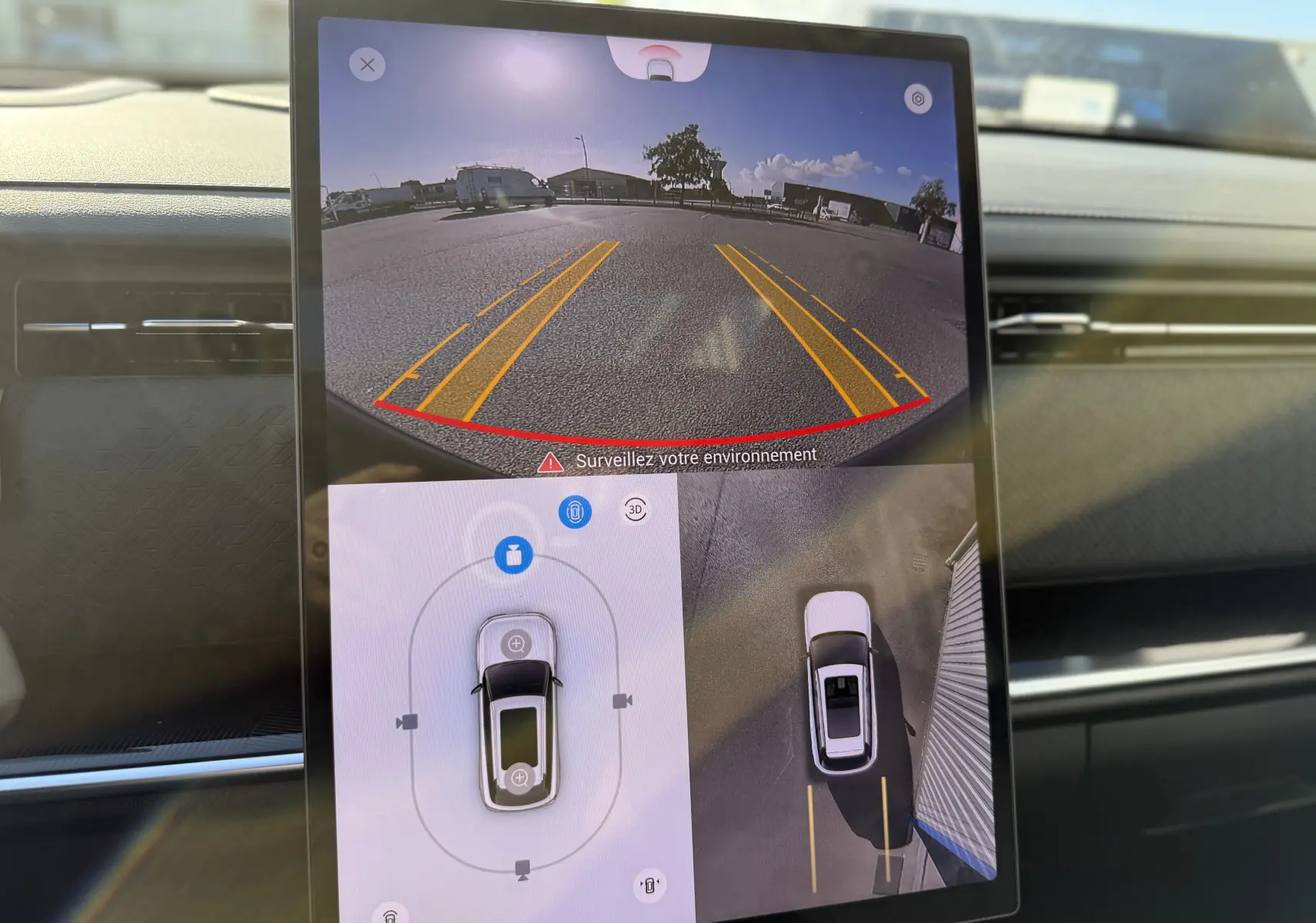 Écran tactile intérieur du JAECOO J7 blanc khaki montrant la caméra de recul et la vue à 360° du véhicule hybride rechargeable.
