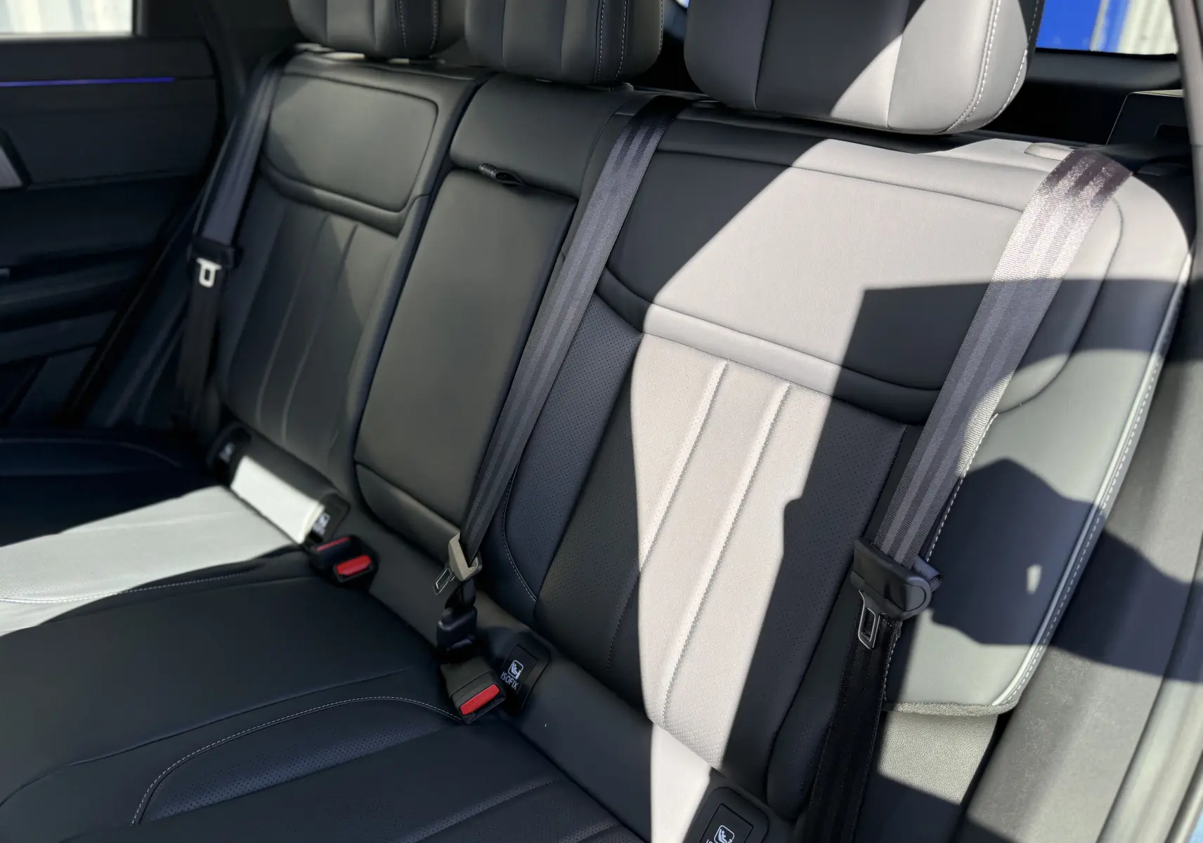 Vue rapprochée des sièges arrière noirs en cuir du JAECOO J7 PHEV 279 CH SHS-P EXCLUSIVE, avec ceintures de sécurité visibles.