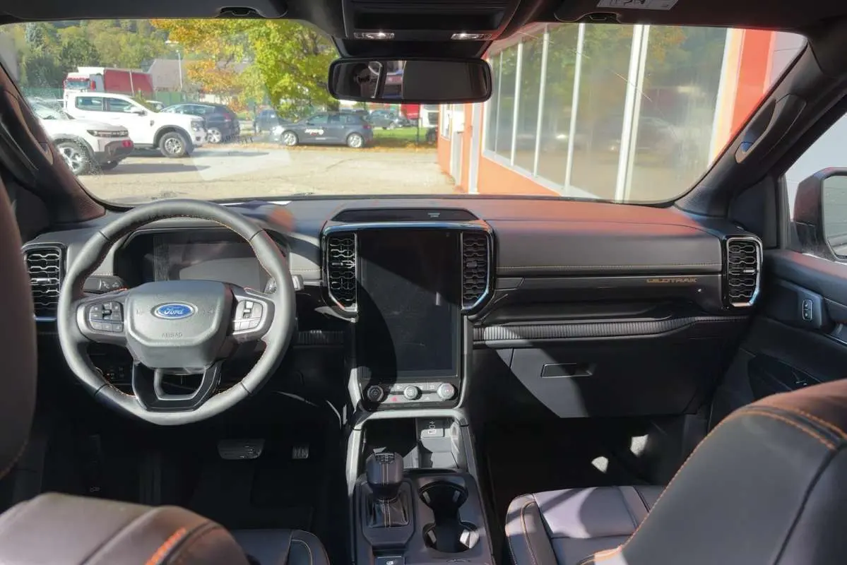 Vue intérieure avant du Ford Ranger gris carbone 2026, avec grand écran tactile vertical et volant cuir multifonctions.