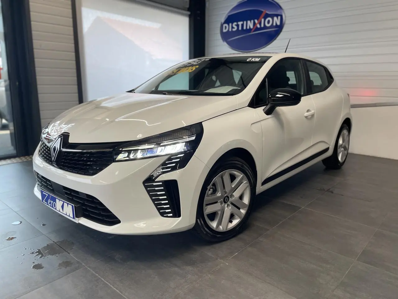 Renault Clio 1.5 Blue dCi 2025 blanc glacier vue 3/4 avant droit avec feux LED et jantes alliage.
