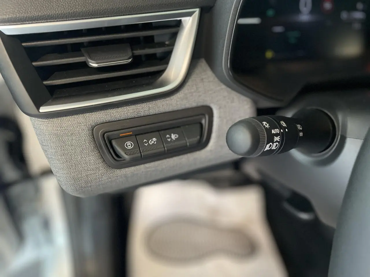 Détail du tableau de bord côté gauche de la Renault Clio 2025 avec commandes éclairage et aérateur encadré chromé satiné.
