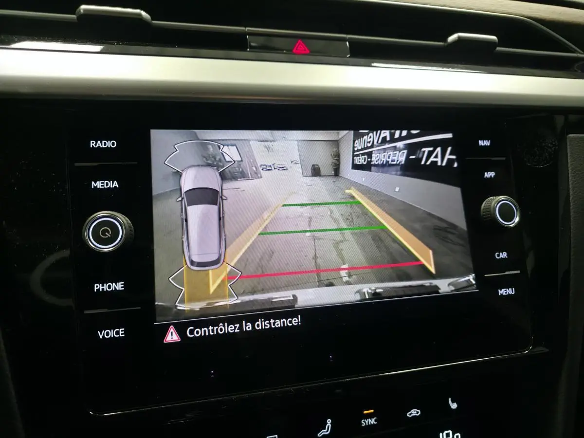 Vue de l'écran multimédia affichant la caméra de recul avec guidage de trajectoire du Volkswagen Arteon blanc.