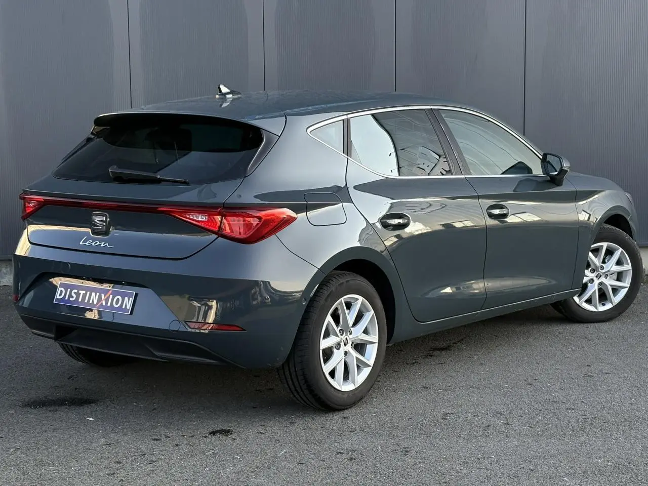 Vue 3/4 arrière droite d'une SEAT Leon 2025 bleu Fjord avec feux arrière LED et jantes alliage 16 pouces.