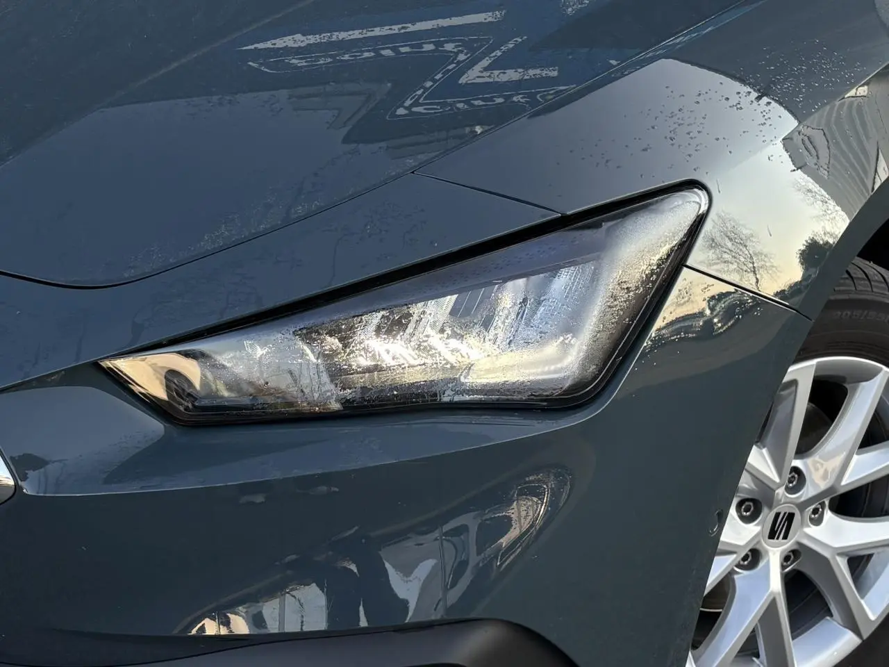 Gros plan sur le projecteur avant droit et la jante alliage 16 pouces d'une SEAT LEON Bleu Fjord 2025.