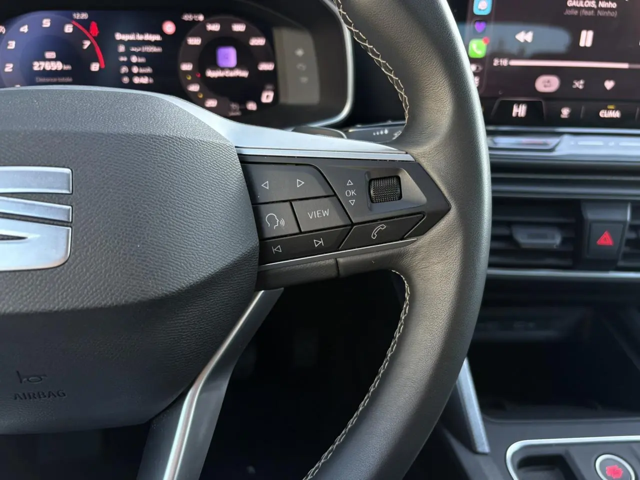 Gros plan sur le volant cuir multifonction à droite du SEAT Leon 2025, avec affichage digital et commandes intégrées.