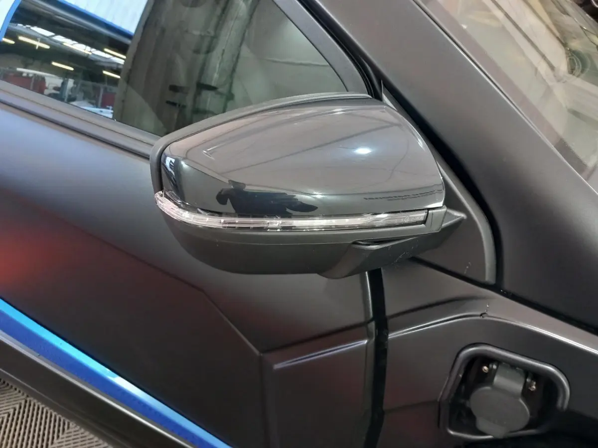 Gros plan sur le rétroviseur côté conducteur noir avec clignotant, sur la portière bleue de l’AIXAM MEGA électrique 2026.