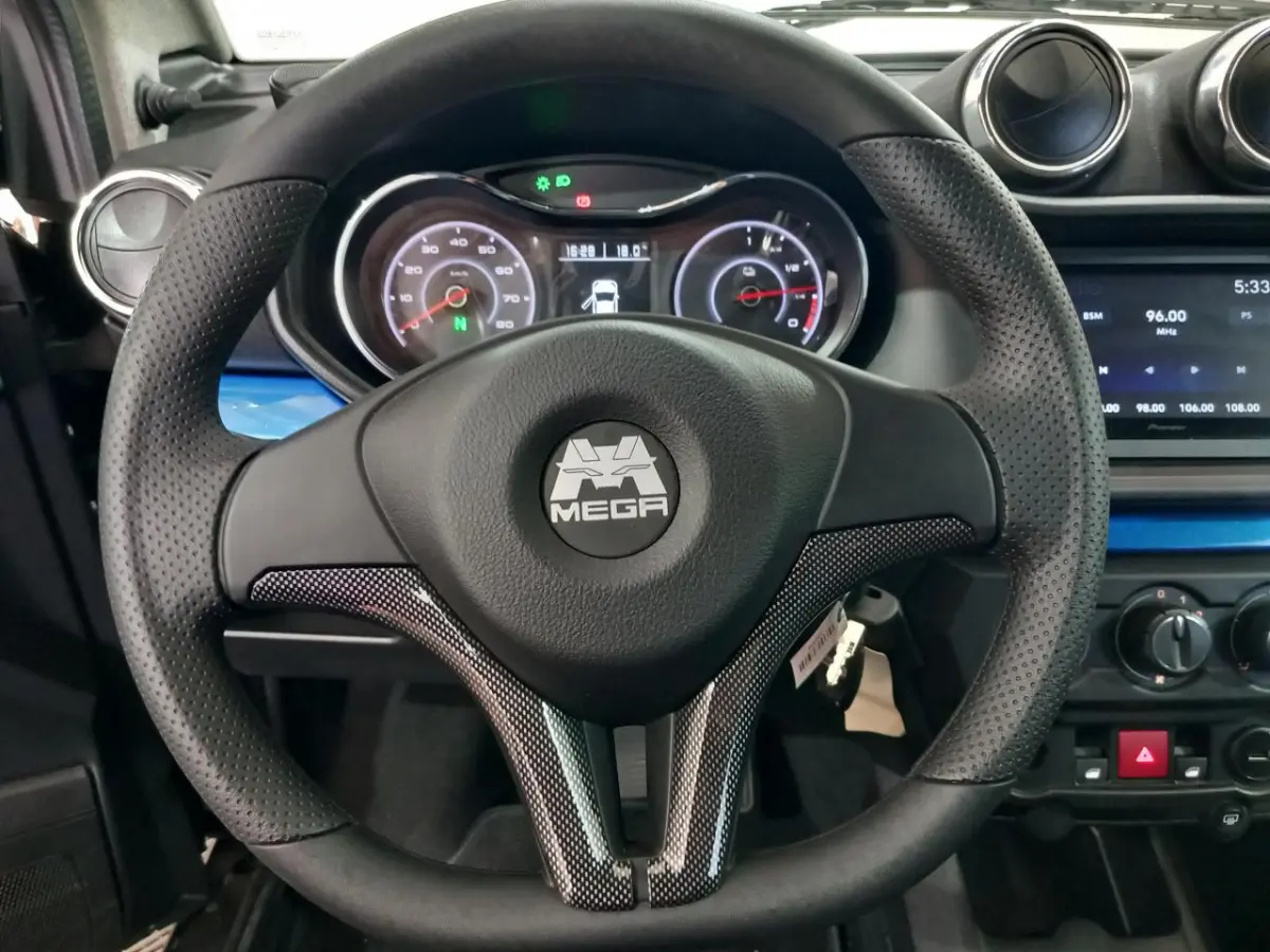 Vue intérieure centrée sur le volant perforé noir avec logo MEGA, tableau de bord et écran multimédia d'une Aixam Mega bleu.
