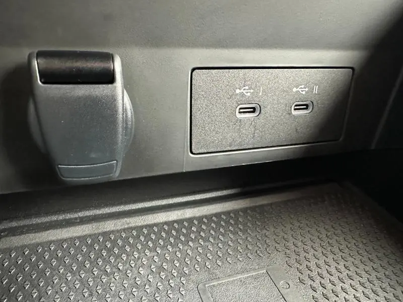 Gros plan intérieur sur deux ports USB-C et prise 12V du Renault Captur rouge 2025, finition Techno.