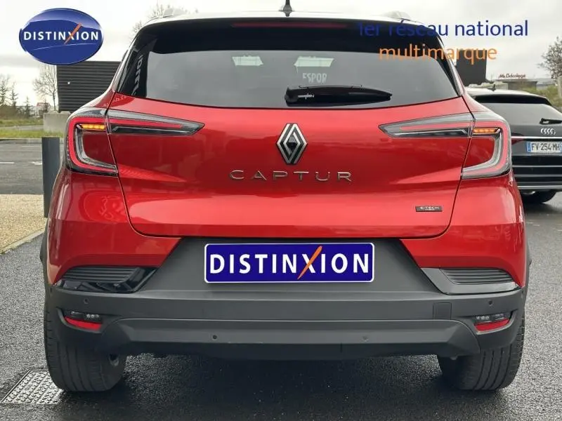 Vue arrière d'un Renault Captur rouge flamme 2025 avec feux arrière LED et logo central distinctif.