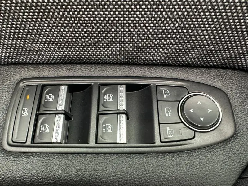 Commande des vitres électriques et réglage des rétroviseurs sur la porte côté gauche d'un Renault Captur rouge.