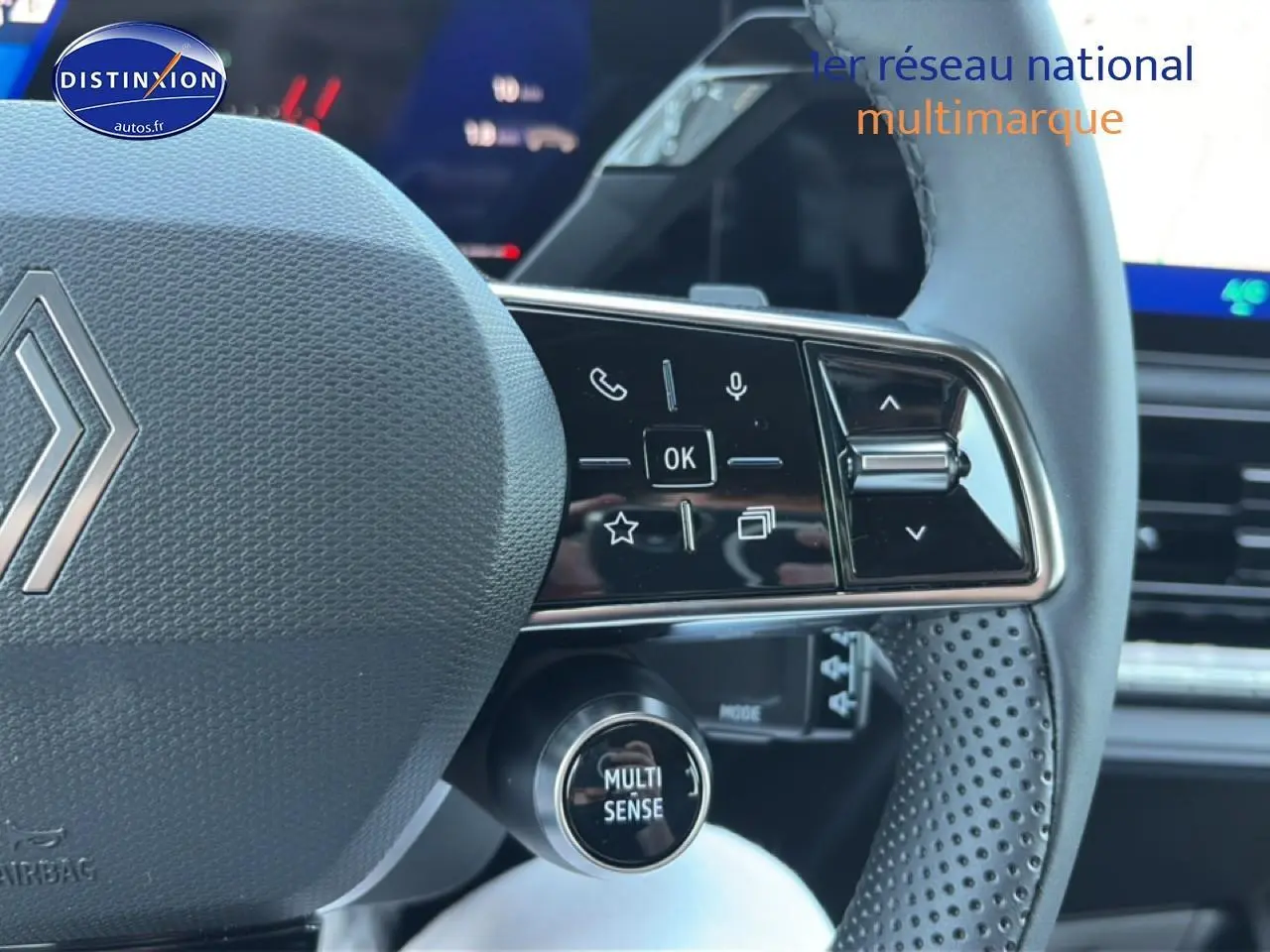 Gros plan sur le volant gris perforé de la Renault Clio VI avec commandes multifonctions et bouton Multi Sense.