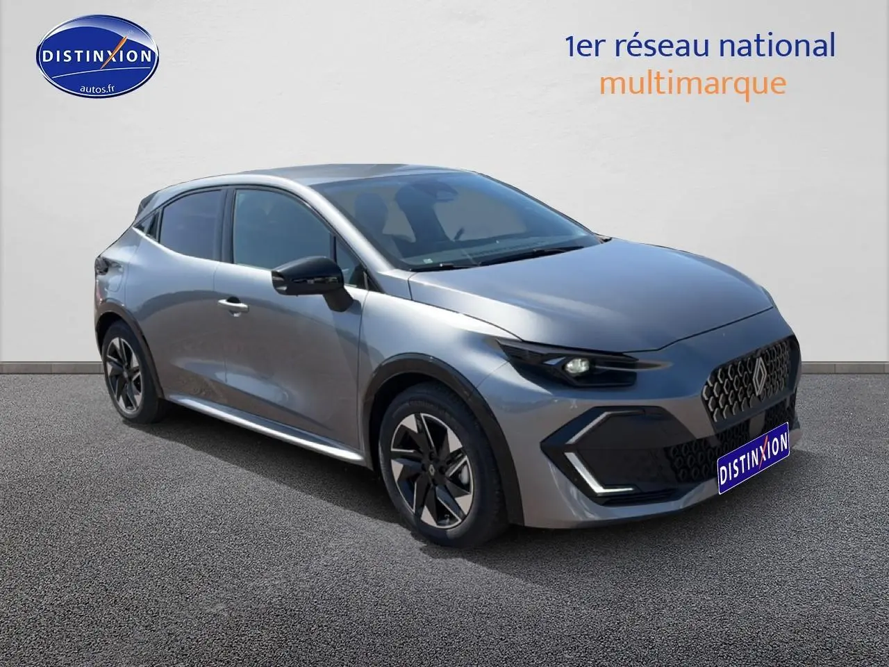 Renault Clio VI gris schiste vue 3/4 avant droit, avec jantes alliage et calandre au design moderne.