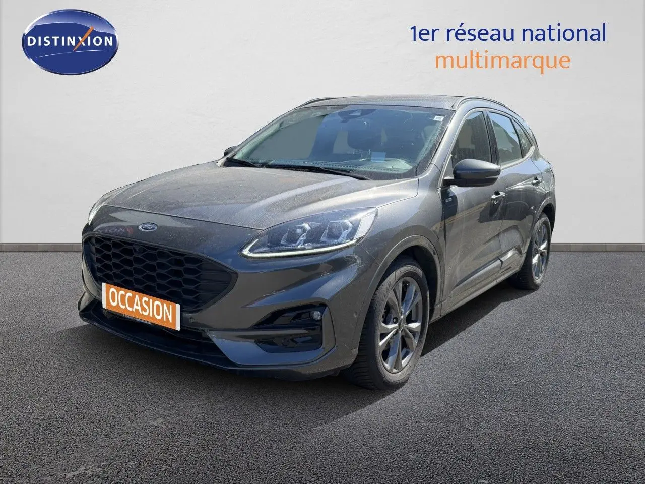 Ford Kuga 2024 gris magnétique métal en 3/4 avant droit avec calandre noire et jantes alliage.