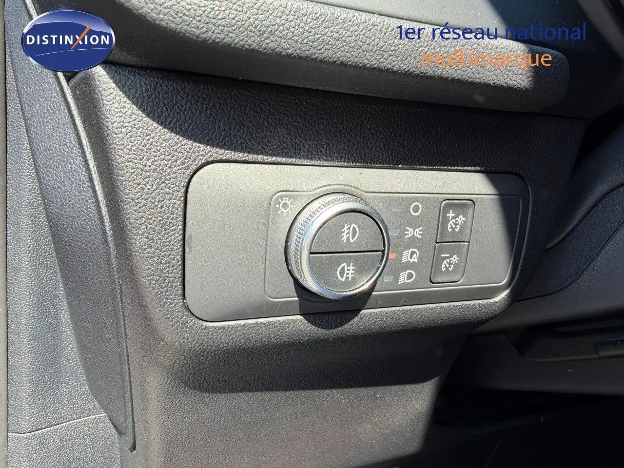 Gros plan sur le panneau de commande des phares du Ford Kuga 2024, finition ST-LINE, intérieur noir texturé.
