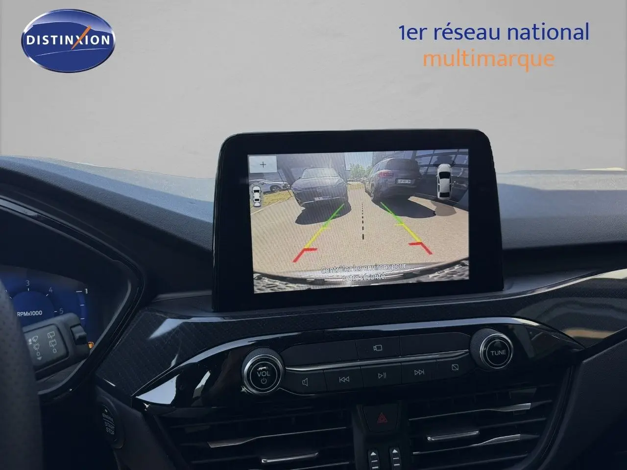 Vue intérieure du tableau de bord du Ford Kuga 2024 gris magnétique, avec écran central affichant la caméra de recul.