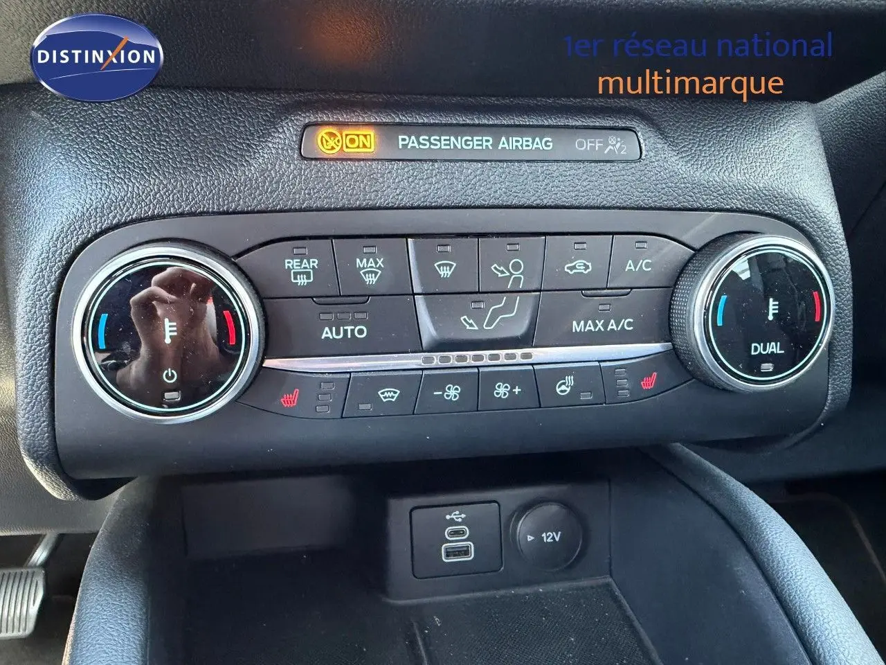 Gros plan sur la console centrale du Ford Kuga 2024 gris magnétique, montrant les commandes de climatisation et ports USB/12V.