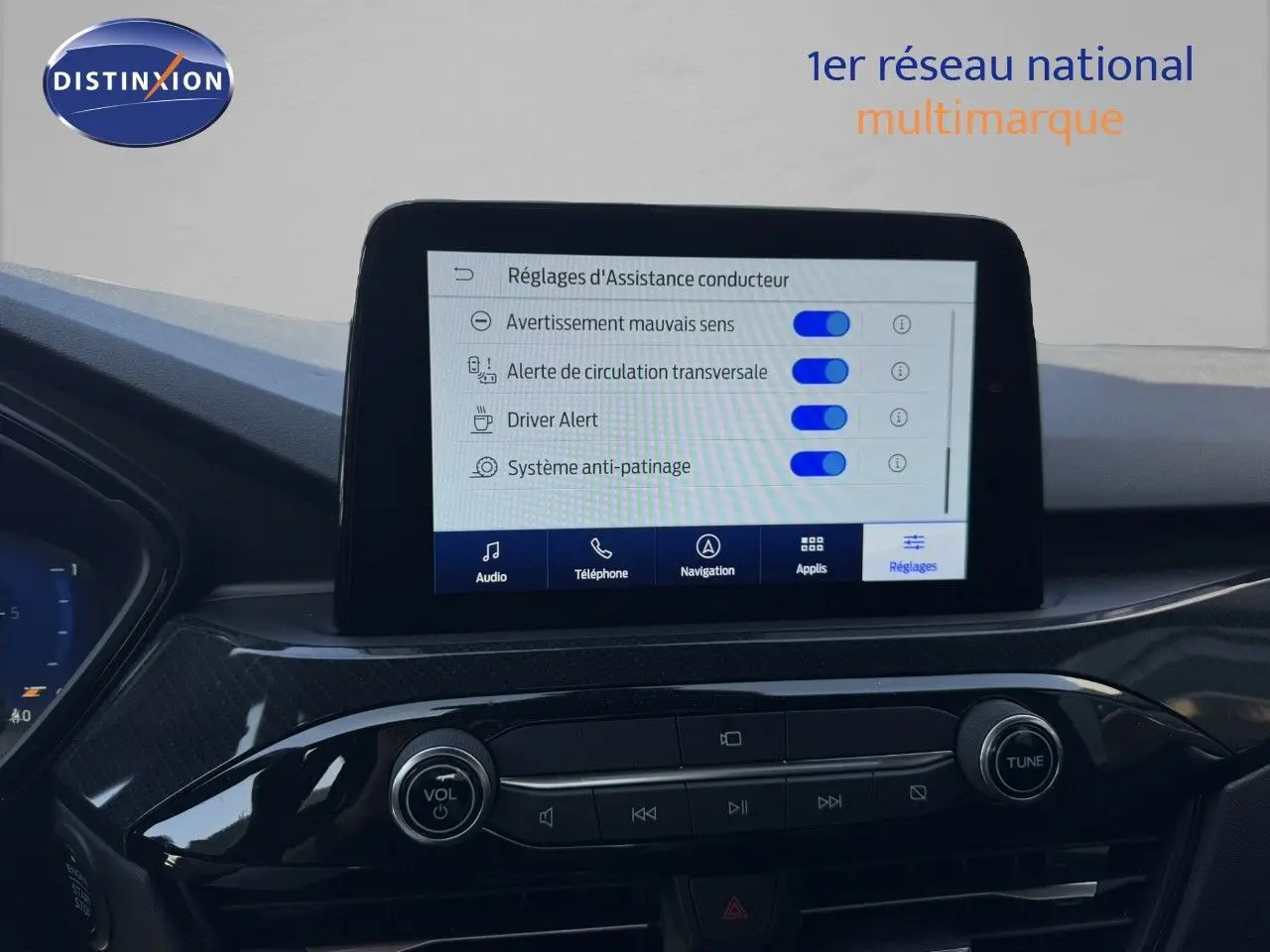 Vue intérieure du tableau de bord du Ford Kuga 2024, écran tactile affichant les réglages d’assistance conducteur.